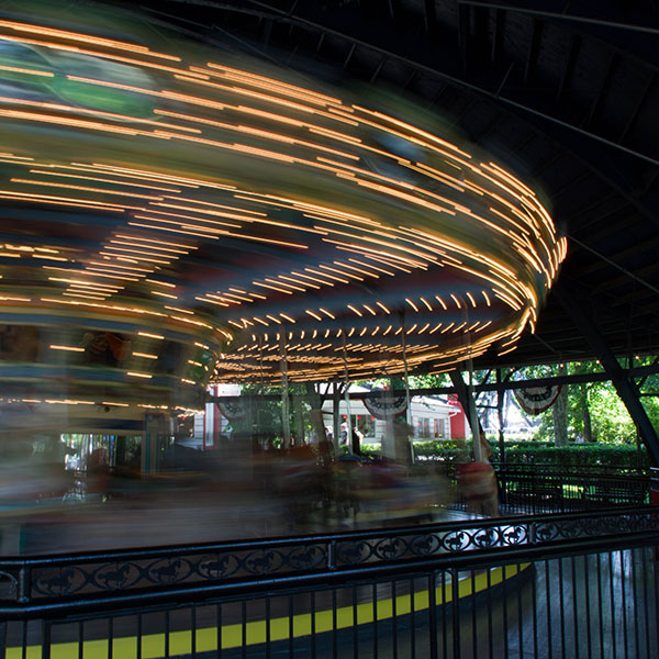 A merry-go-round spins into a blur of light
